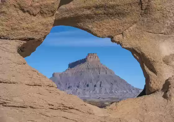 One Hole Arch early morning Arches framing Factory Butte near Hanksville, Utah