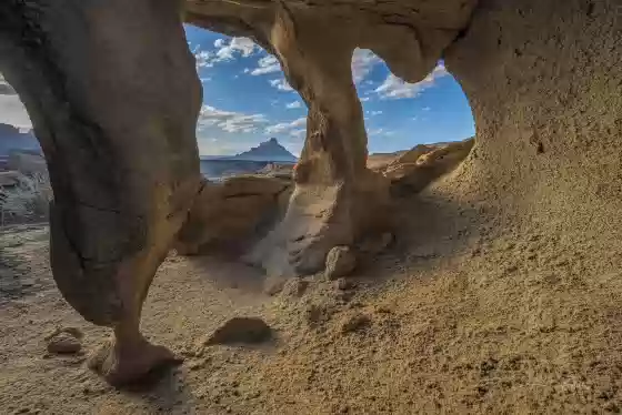 Three Hole Arch Arches framing Factory Butte near Hanksville, Utah