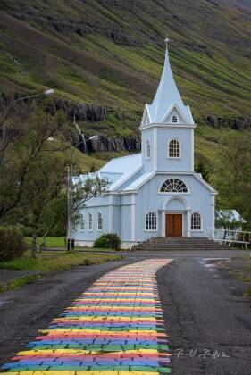 Rainbow Road and Blue Church Rainbow Road and the Blue Church in Seydisfjordur, Iceland.